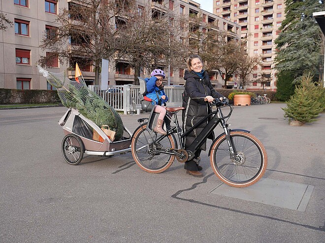 Jelena und Ella bringen ihre Tanne im Anhänger nach Hause.